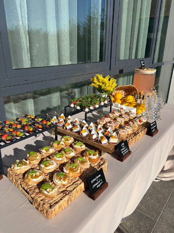 Фуршетный стол с канапе и закусками у панорамных окон